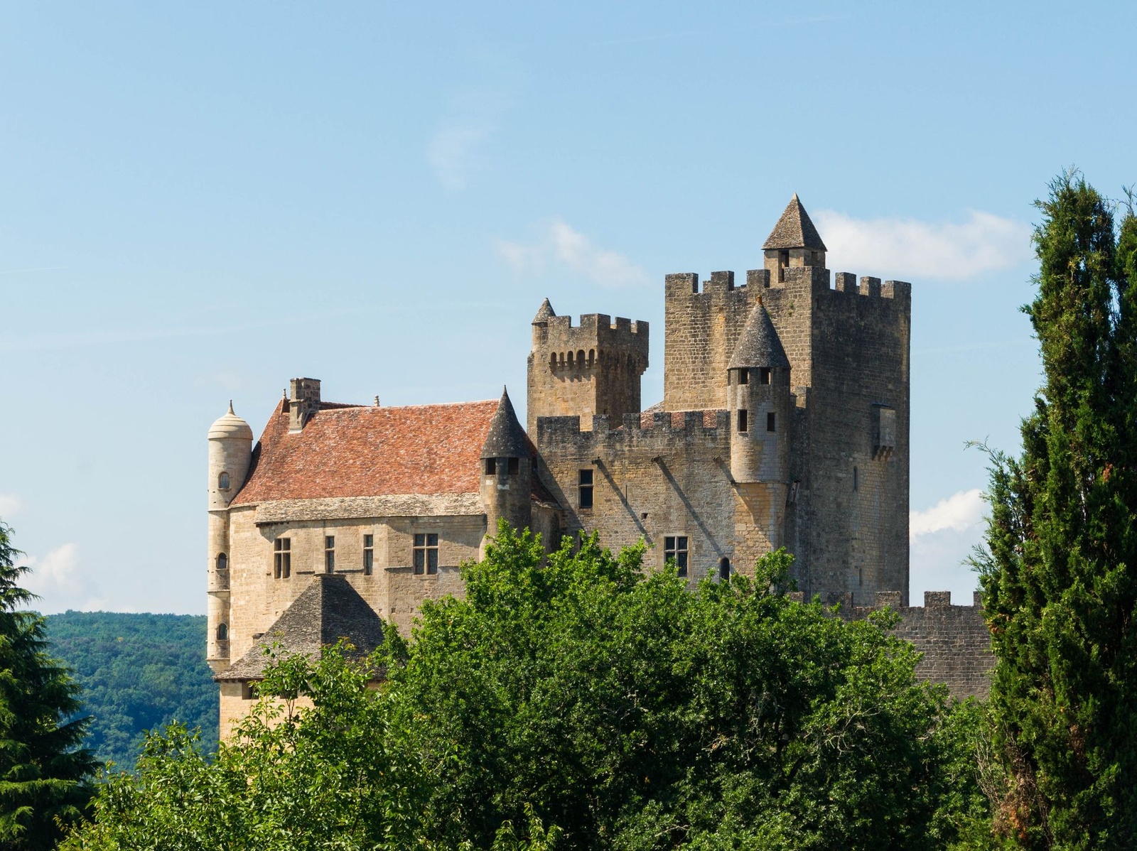 Le château de Beynac au-dessus des arbres, sous un ciel bleu