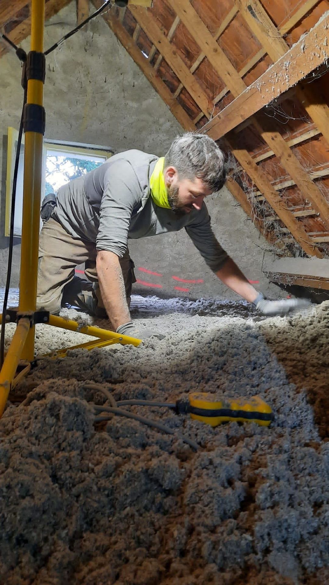 Travaux d’isolation dans les combles de la maison, sous la charpente apparente.