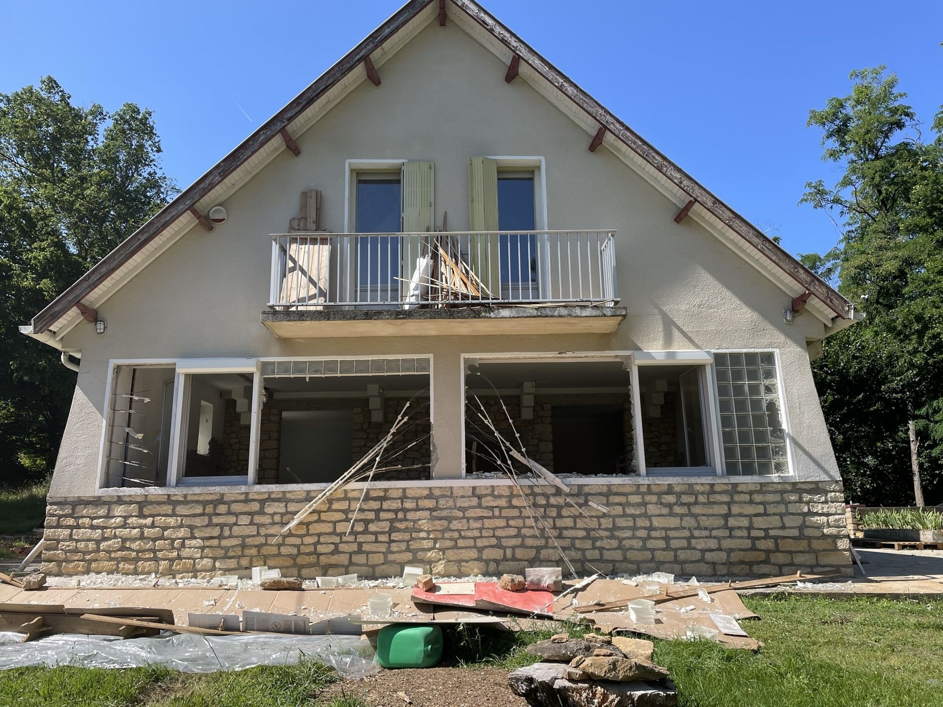 Façade de la Casa pendant les travaux, avec grandes ouvertures et matériaux devant la maison.